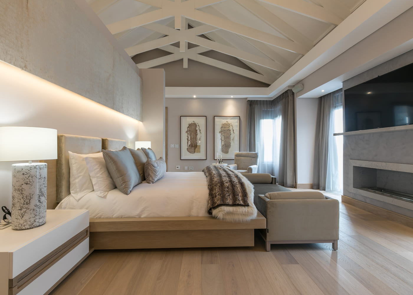 Principal bedroom with a fireplace under a trussed ceiling